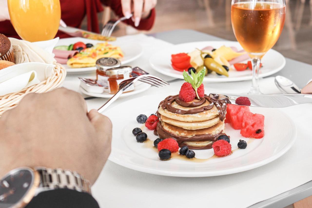The Bentley Luxury Hotel & Suites Ντόχα Εξωτερικό φωτογραφία A stack of pancakes with fruit